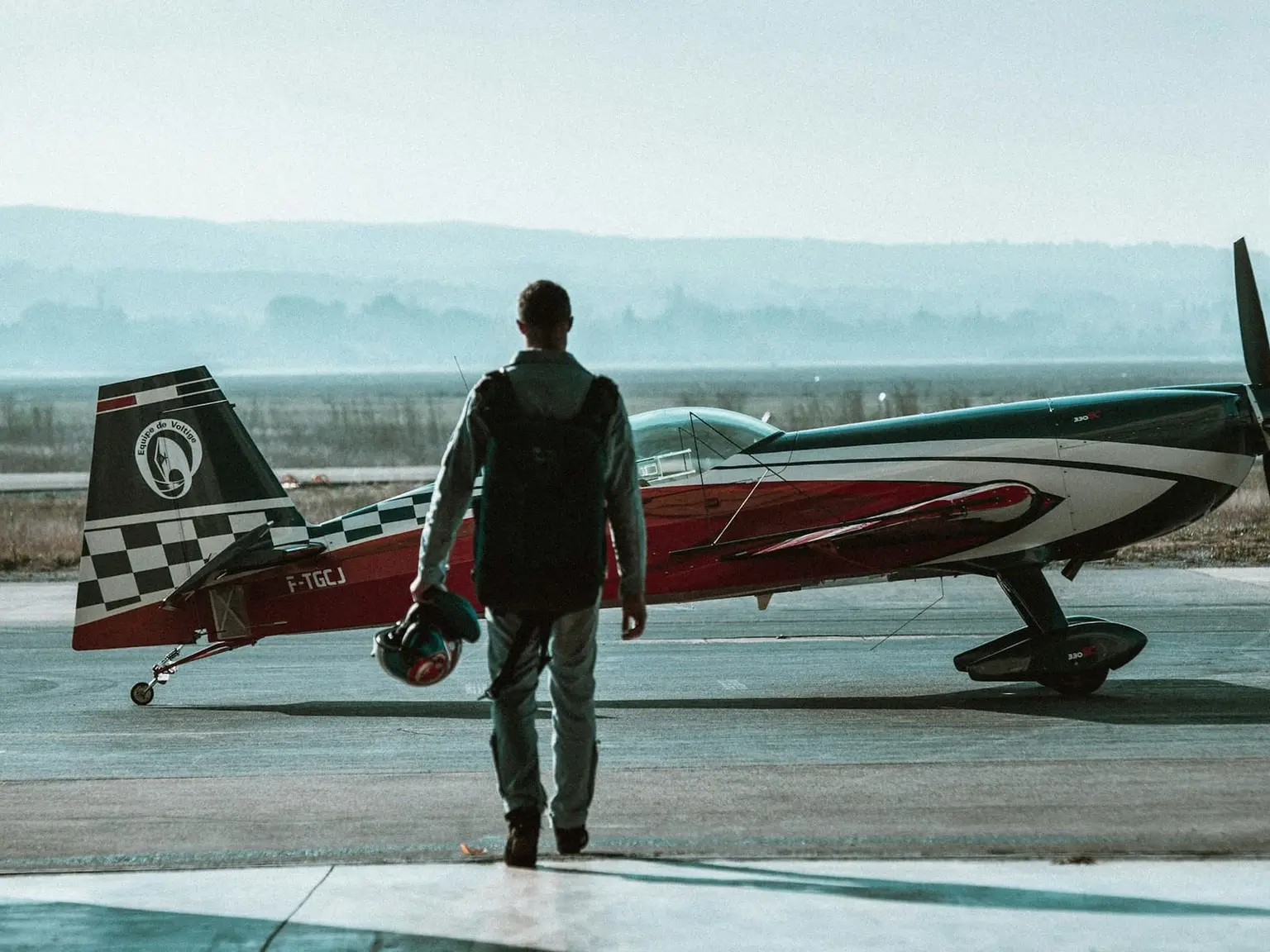 A pilot walking across the apron towards a light aircraft